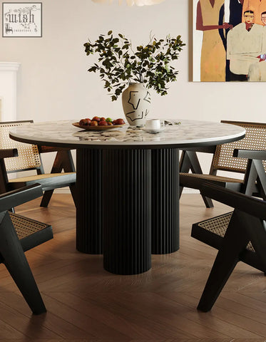 Round marble-top dining table with black ribbed cylindrical legs perfect for stylish round dining spaces