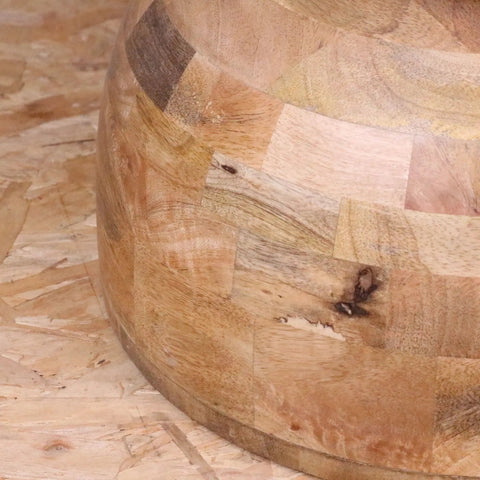 A round chunky jivana mango wood side table with a light and dark patchwork design made of natural wood pieces