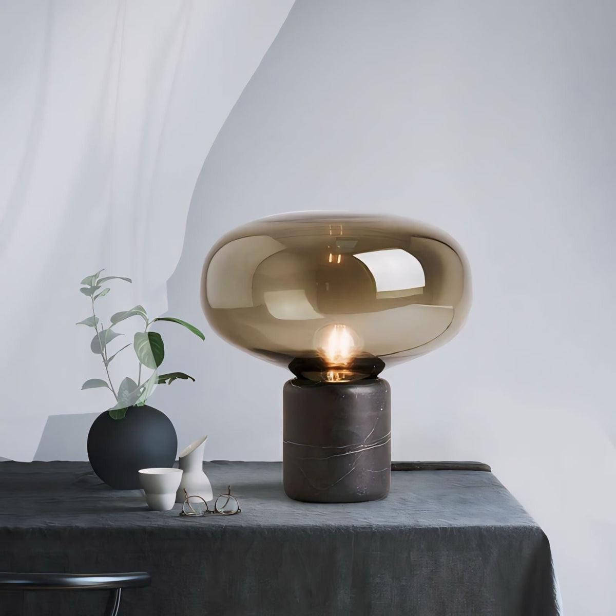 A sleek johano light amber-tinted glass lamp with a polished marble base perfect for stylish home decor