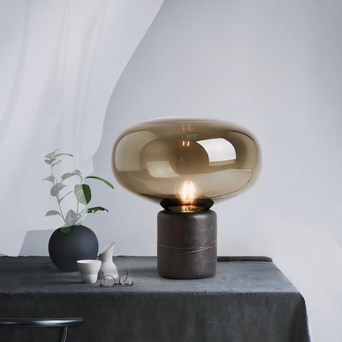 A sleek johano light amber-tinted glass lamp with a polished marble base perfect for stylish home decor