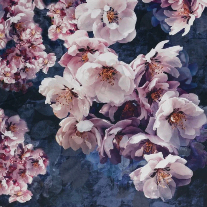 A high quality jolanda floral velvet cushion with pink and lavender cherry blossoms on a textured dark blue background