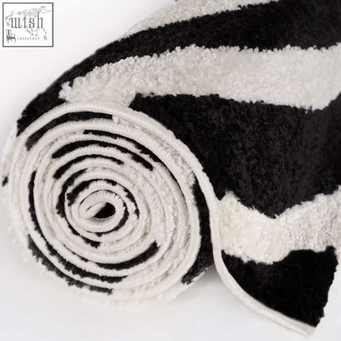 A soft textured plush black and white striped bath rug from joli striped black collection
