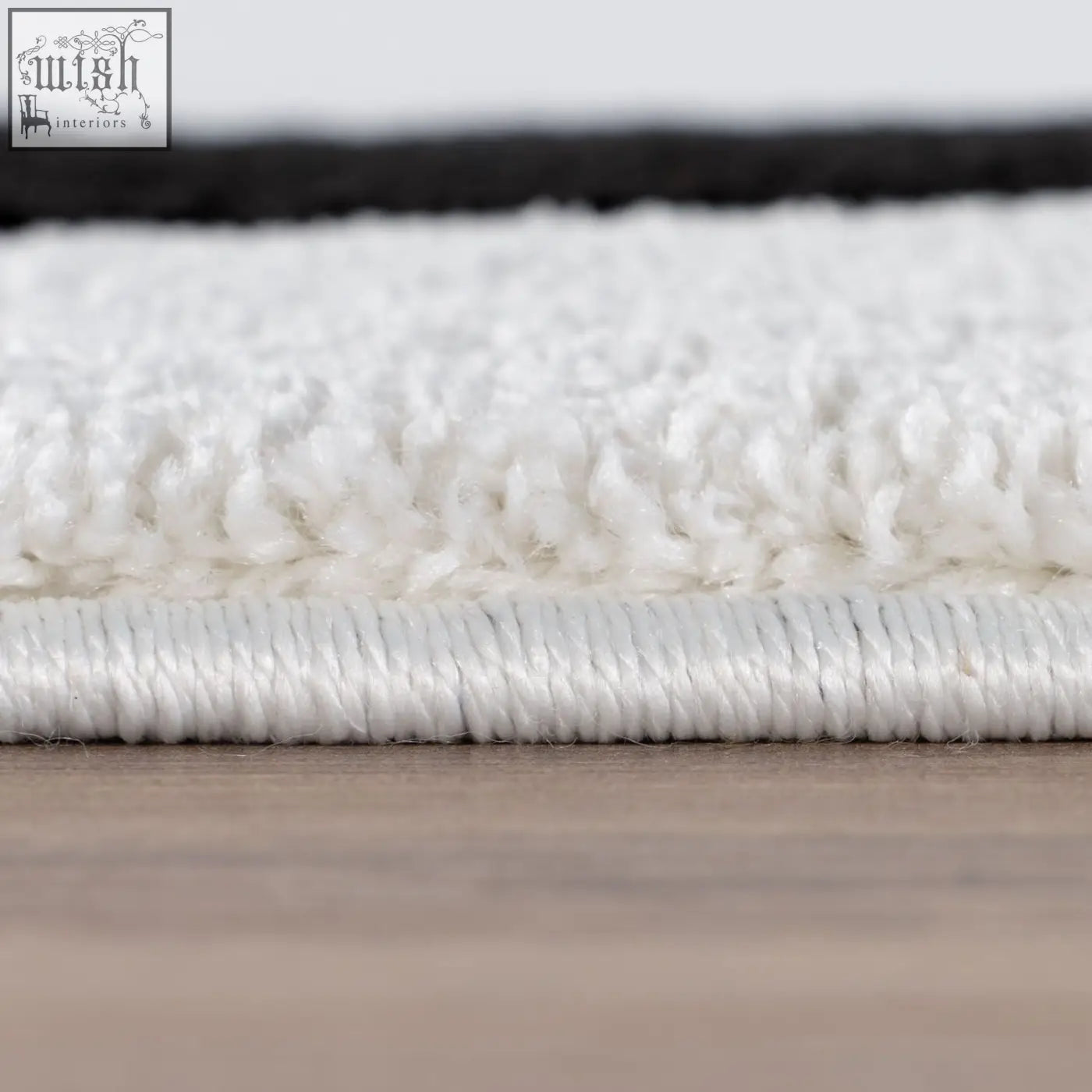White plush rug with soft textured surface and stitched border in joli striped black style