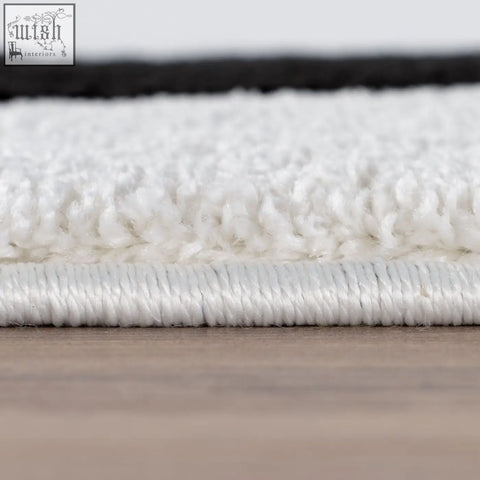 White plush rug with soft textured surface and stitched border in joli striped black style