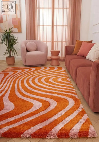 A plush joli striped orange rug with a shaggy texture and flowing striped pattern in orange and white