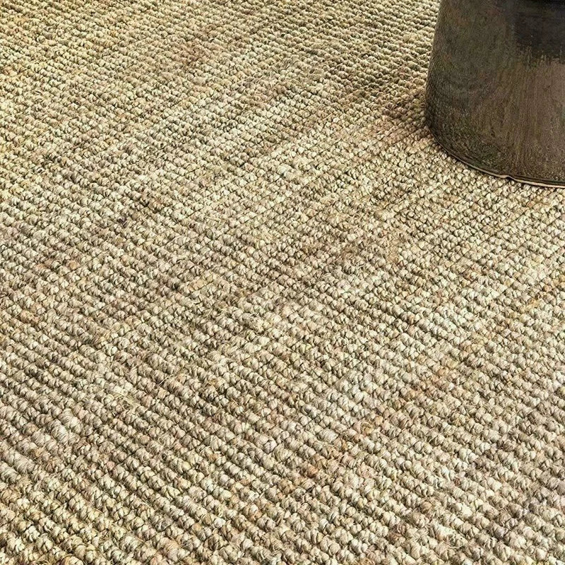 Beige woven joto rug made of natural jute fibers with a textured surface perfect for cozy home decor