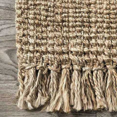 Natural fiber joto rug with textured woven pattern and fringed edges perfect for cozy living spaces