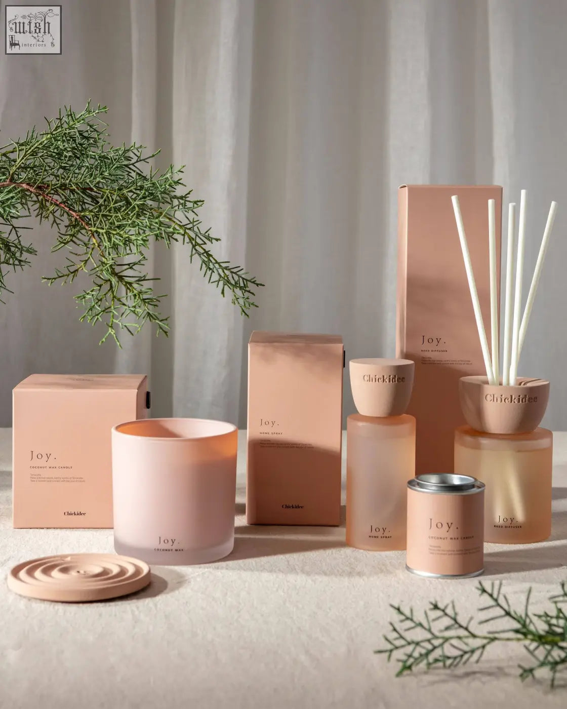 A soft pink matte ceramic candle with minimalist design and joy printed for joy clay home spray fans