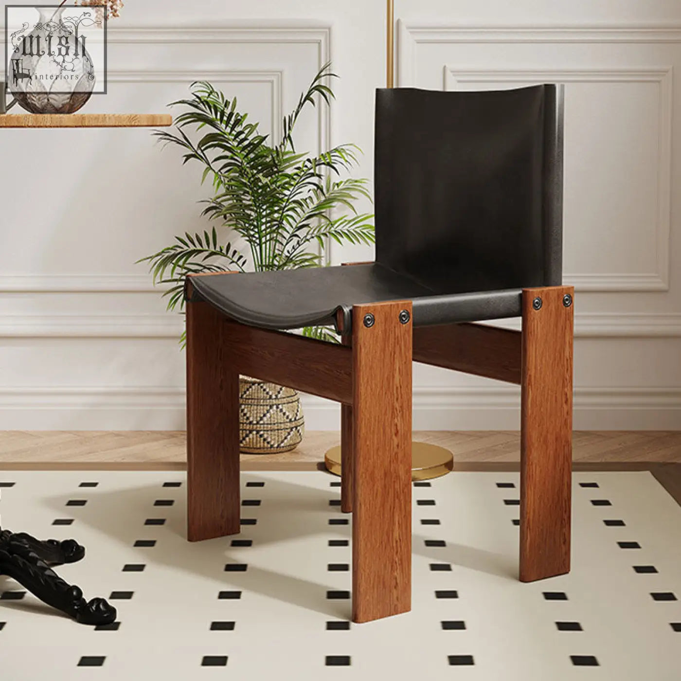 Black leather seat and backrest of judith dining chair mounted on sturdy wooden frame with metal fasteners visible