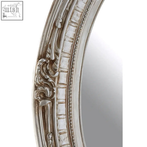 Silver champagne oval framed wall mirror with ornate carved detailing and distressed finish for elegant decor