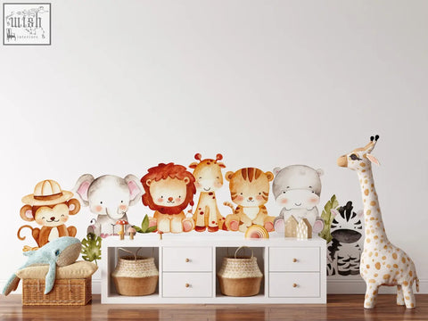 A charming collection of reusable jungle wall decals featuring cartoon safari animals in soft watercolor tones for kids rooms