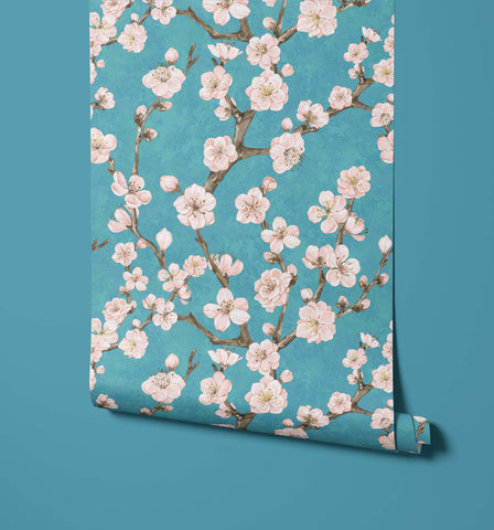 A roll of junta wallpaper with delicate pink cherry blossoms on vibrant teal background perfect for home decor