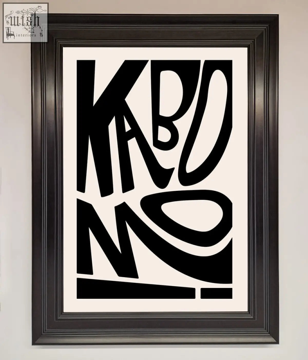 Black framed kaboom framed print with bold stylized abstract typography on a white background for wall decor