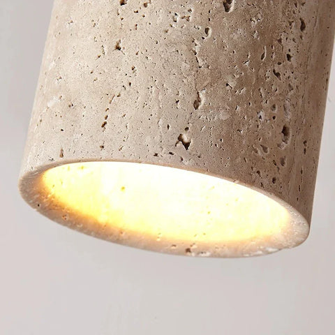A kaku light cylindrical concrete pendant light with textured beige surface and warm yellow glow inside