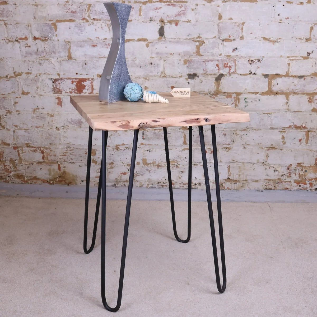 Light-colored kalan live edge wooden side table with black hairpin legs and natural edge wooden design