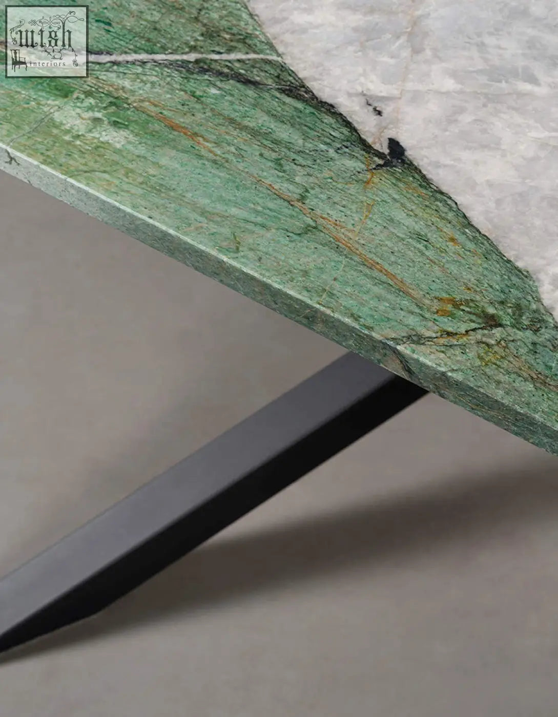 Kamara dining table with green marble tabletop featuring natural veining and sleek black metal leg for marble dining
