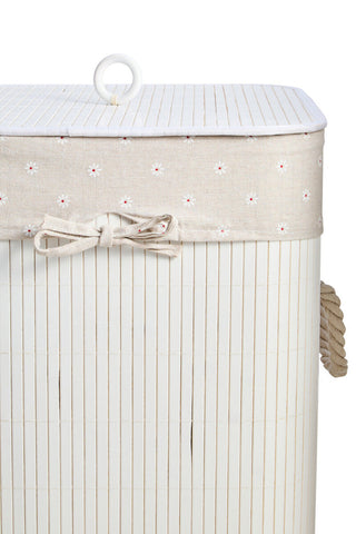 Beige woven laundry hamper with white floral trim and matching fabric bow in a kankyo white square design