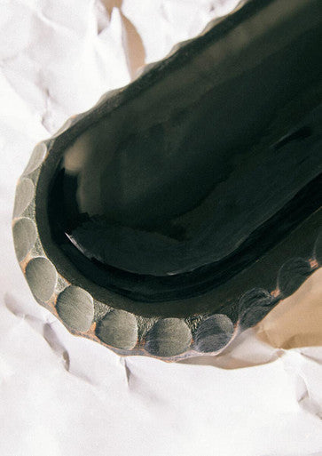 Black ceramic inkwell with textured circular rim paired with kara black mango wood serving dish
