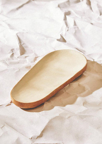 Beige kara mango wood small oval serving dish with smooth raised rim and subtle wood grain texture