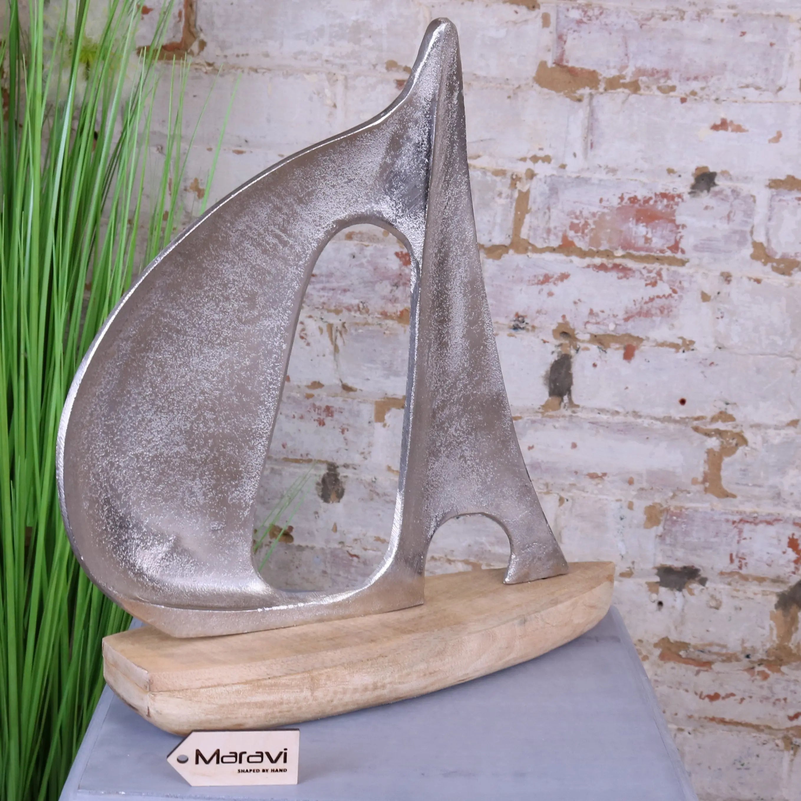 Silver metallic kasba boat ornament with textured brushed finish on light wood base perfect for decoration