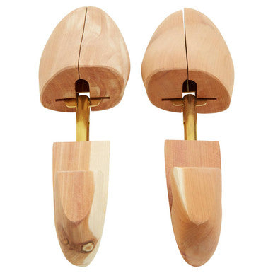 Pair of light-colored cedar wood shoe shapers with brass inserts designed for maintaining shoe shape