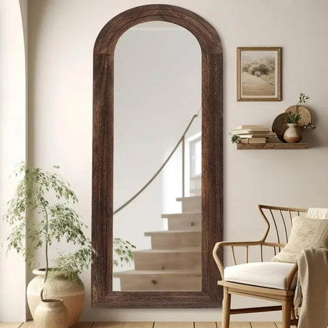 A tall arched kayo mirror with a rustic dark brown wooden frame perfect for adding charm to your space