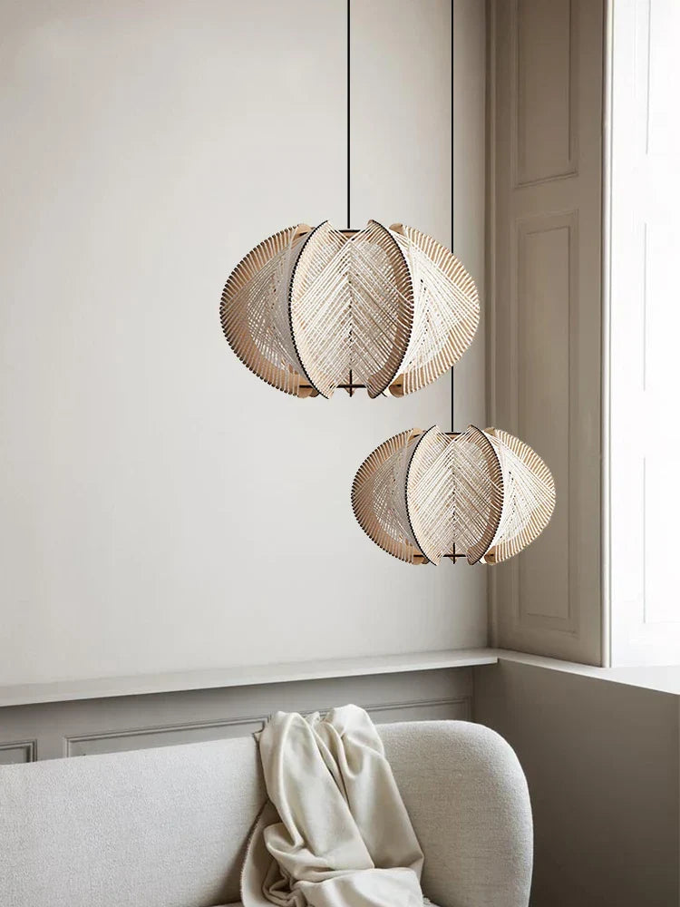 Two beige leaf-shaped kazaru light pendant lights with woven wooden texture hanging from black cords