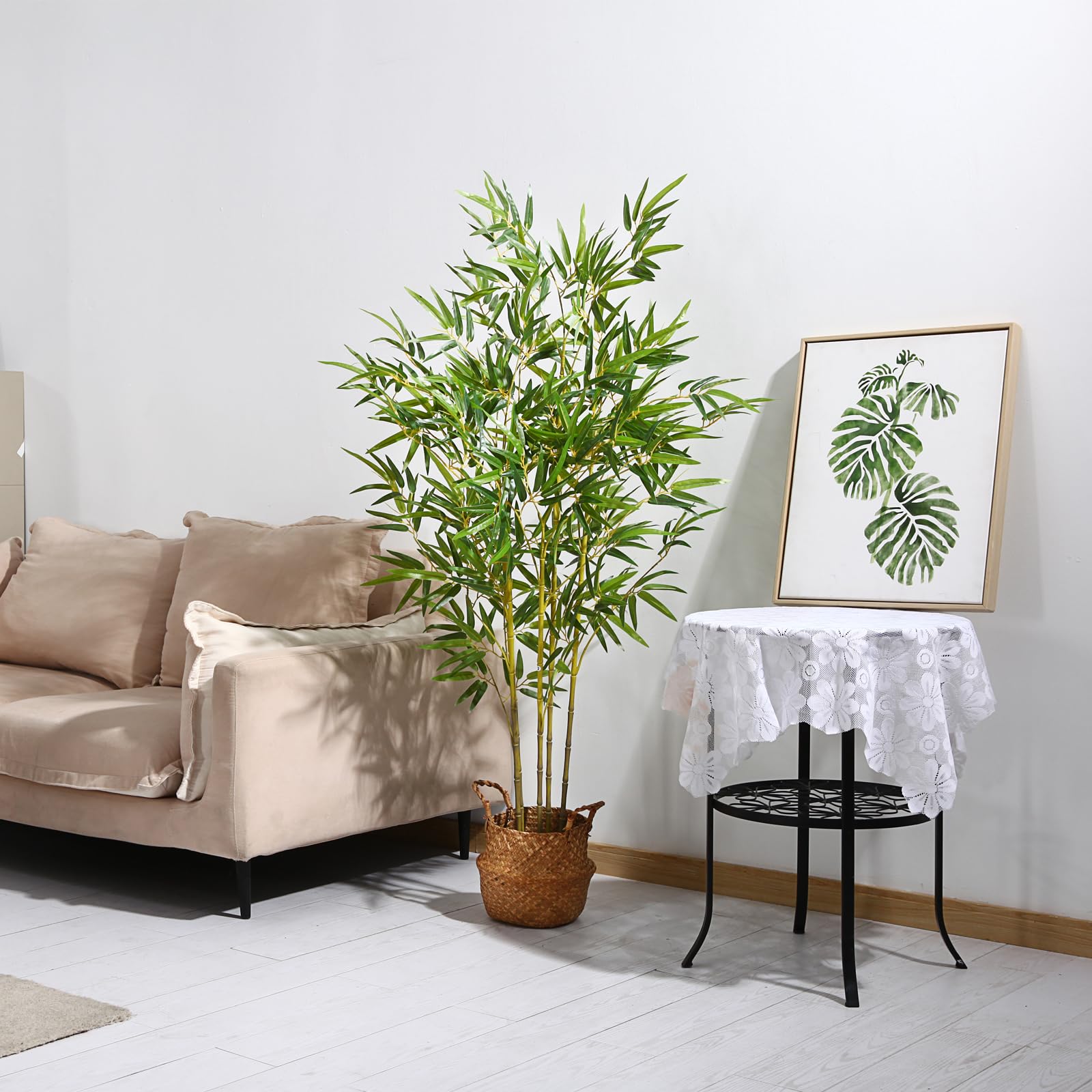 Tall artificial bamboo plant with vibrant green leaves and slender yellow green stalks in woven wicker basket for indoor outdoor use