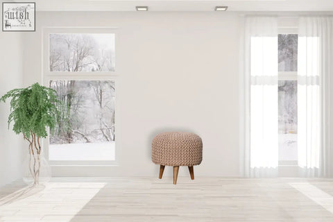 Beige fabric keeva beige round footstool featuring a knitted texture and wooden legs for cozy seating or decor