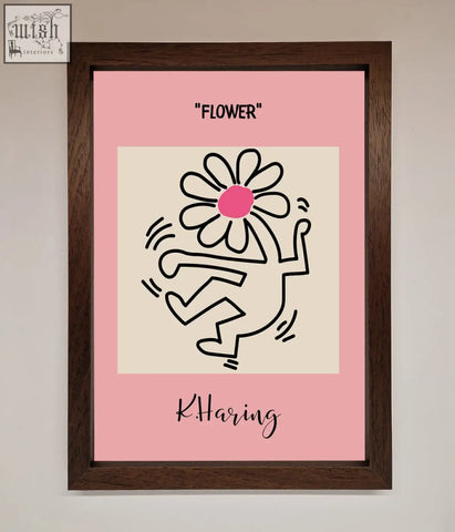 A framed poster of a keith haring flower pink featuring a black line drawing with a pink flower in a dark brown frame