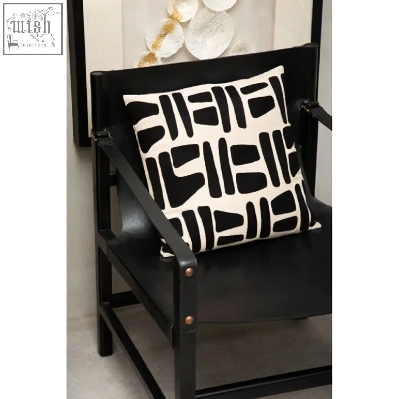 Black and white geometric throw pillow on a kendari armchair with a teak wood frame minimalist design