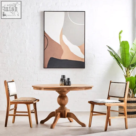 Round wooden table with turned pedestal base and three splayed legs paired with kendari natural leather teak wood dining chair