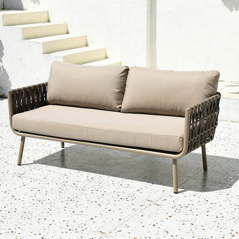 Beige cushioned kenneth outdoor sofa with woven dark brown frame and metal legs in an outdoor sofa set