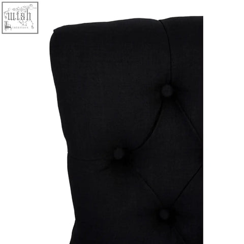 Black linen dining chair with a Kensington Townhouse black tufted fabric headboard and dark button accents