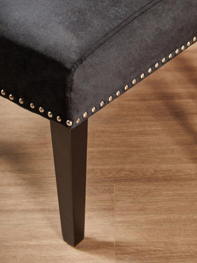 Dark gray upholstered kensington townhouse black winged dining chair with metallic nailhead trim along the edge