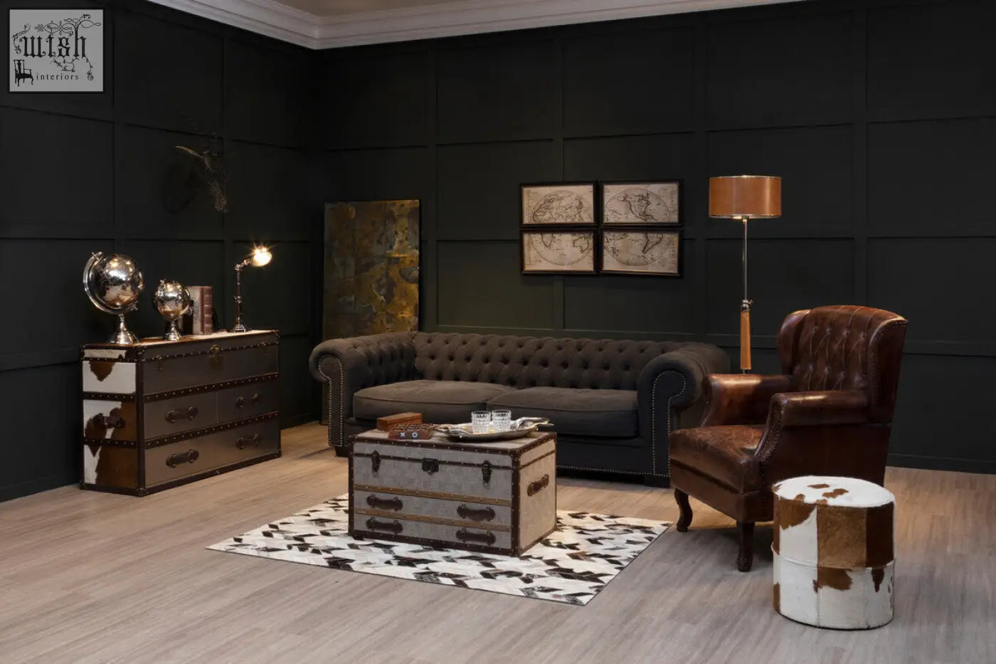 Dark gray tufted leather sofa with nailhead trim complementing kensington townhouse brown and white cowhide cabinet