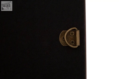 Black textured case with brass-colored clasp shown on the back of a genuine cowhide wall mirror from Kensington Townhouse