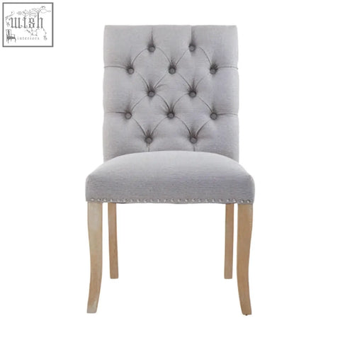 Grey linen dining chair with tufted grey linen upholstery and light wood legs perfect for dining spaces