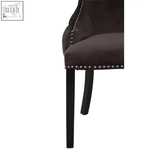 Dark brown velvet chair with silver nailhead trim and black legs in the style of kensington townhouse grey velvet button tufted dining chair