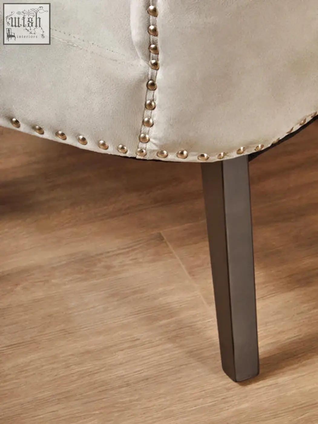 Cream-colored leather kensington townhouse grey winged dining chair with silver nailhead trim and dark metal legs