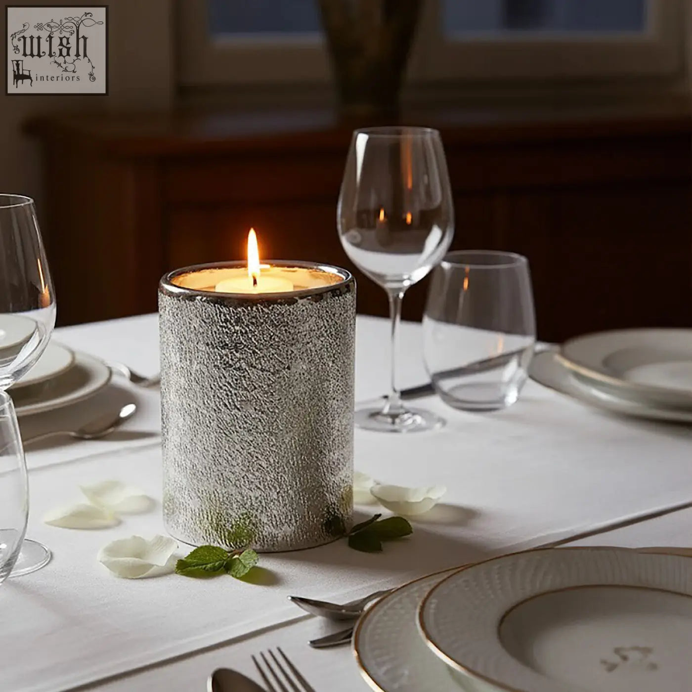 Silver textured candle holder with a lit flame perfect as a stylish silver candle for cozy spaces