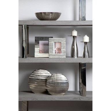 Small silver candle holder made of silver metal with smooth reflective surface and subtle horizontal ridges