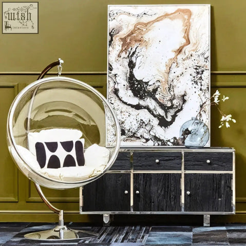 Clear glass bubble chair with chrome stainless steel frame and base shown next to kerala black sideboard black sideboard