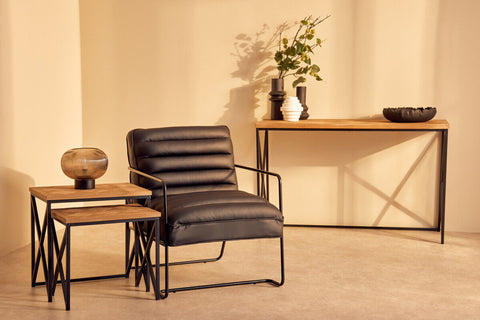 Black leather armchair with ribbed back and seat on sleek black metal frame paired with kickford parquet fir wood set