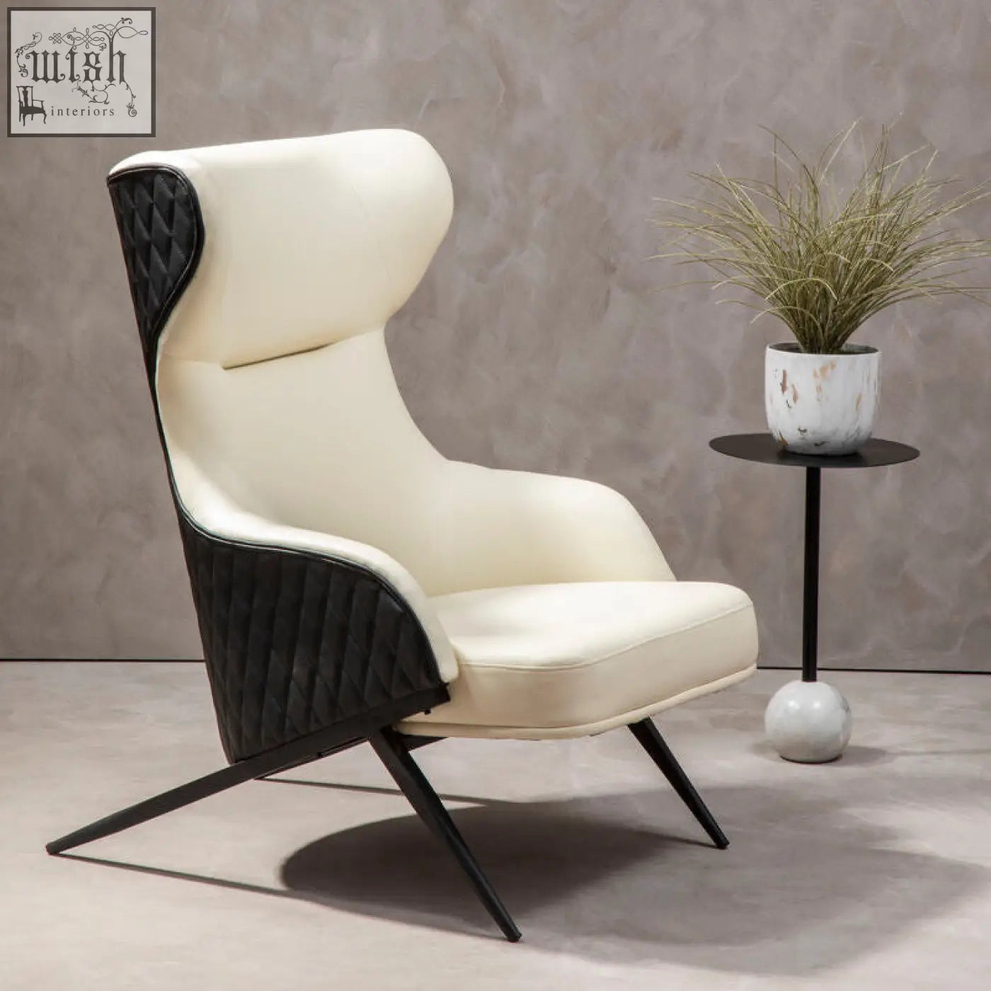 Cream-colored kiev ivory faux leather armchair with black quilted accents and sleek angled metal legs