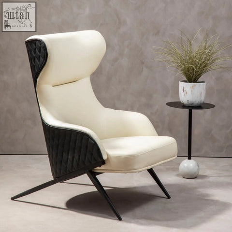 Cream-colored kiev ivory faux leather armchair with black quilted accents and sleek angled metal legs