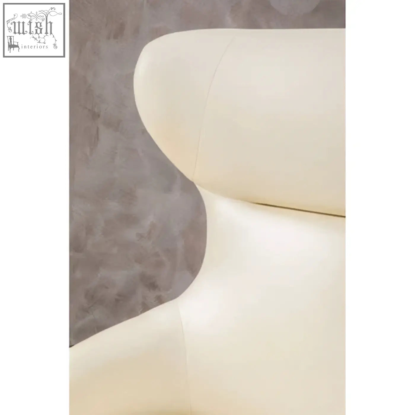 Cream-colored kiev ivory armchair with smooth curved contours and subtle stitching in faux leather upholstery