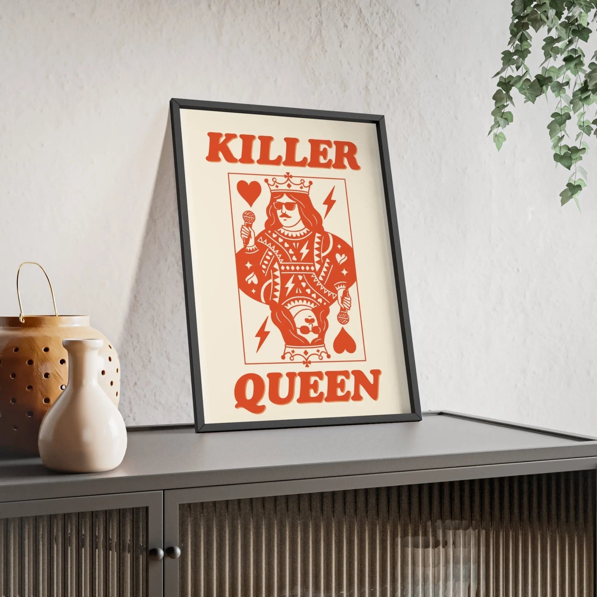 A framed killer queen poster with a red stylized playing card design featuring lightning bolts and hearts on off-white background