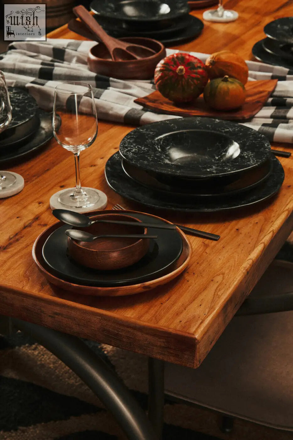 Black marble-effect ceramic dinnerware with matte finish and subtle veining on rustic wooden table with white marble round coasters