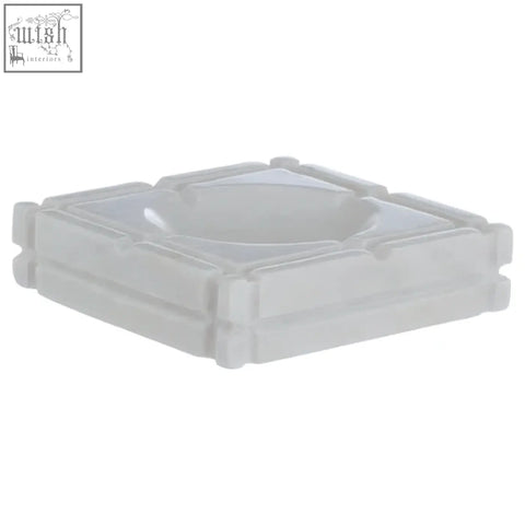 Kira white marble ashtray is a white plastic square ashtray with raised edges resembling a marble ashtray design
